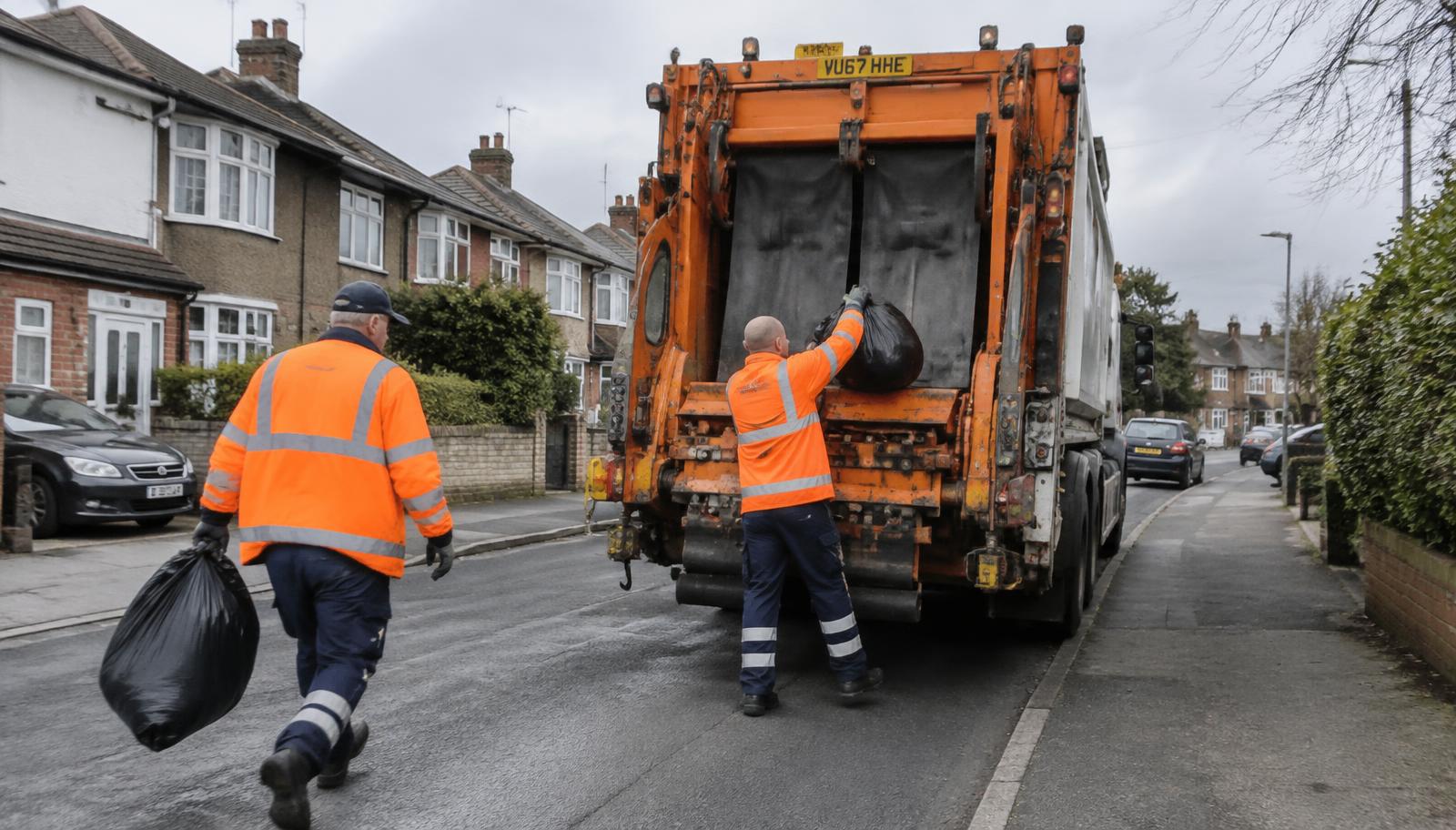 Waste collection vehicle collecting household rubbish