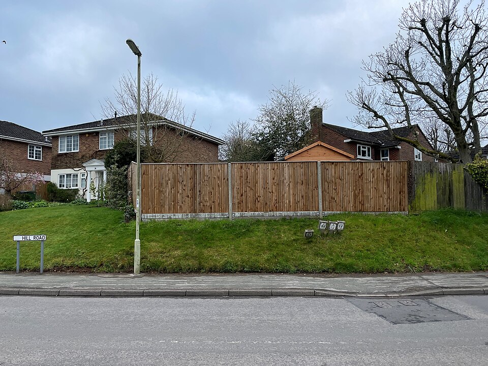 A garden shed and fencing behind a residential property, an example of the kind of garden structure that may need dismantling and removing